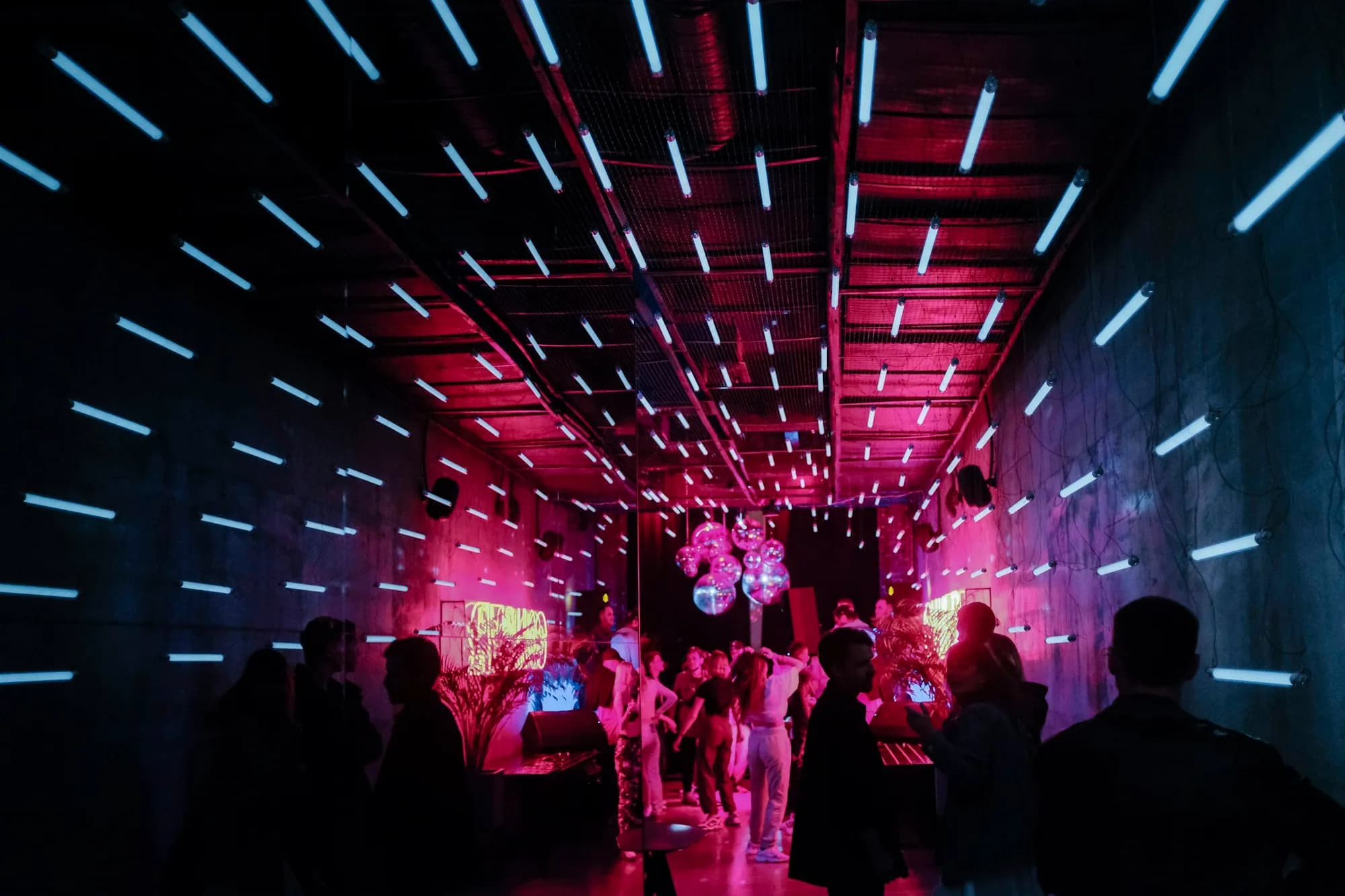 Dancers moving in a dark, moody lounge