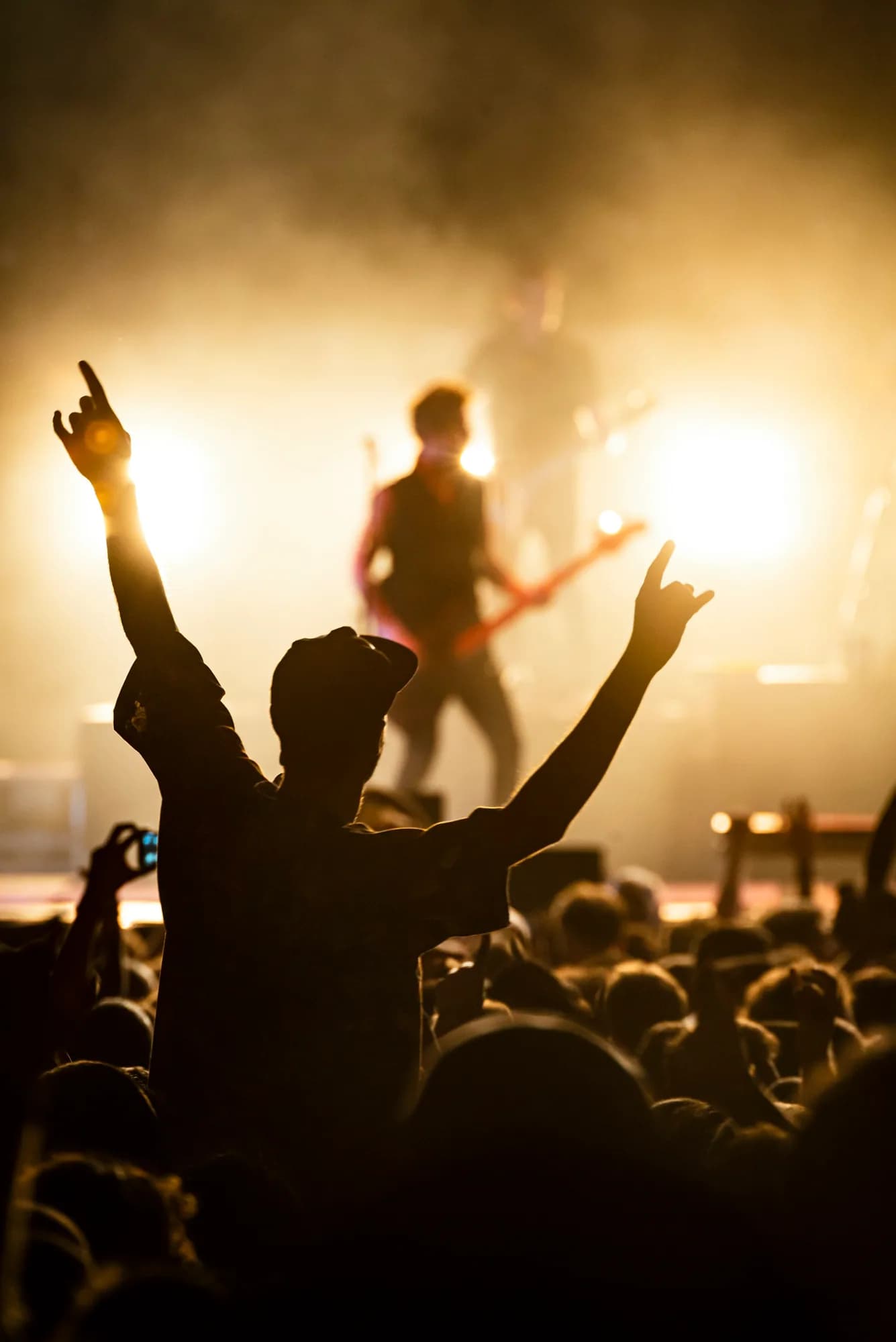 A nightclub crowd silhouetted in warm gold light