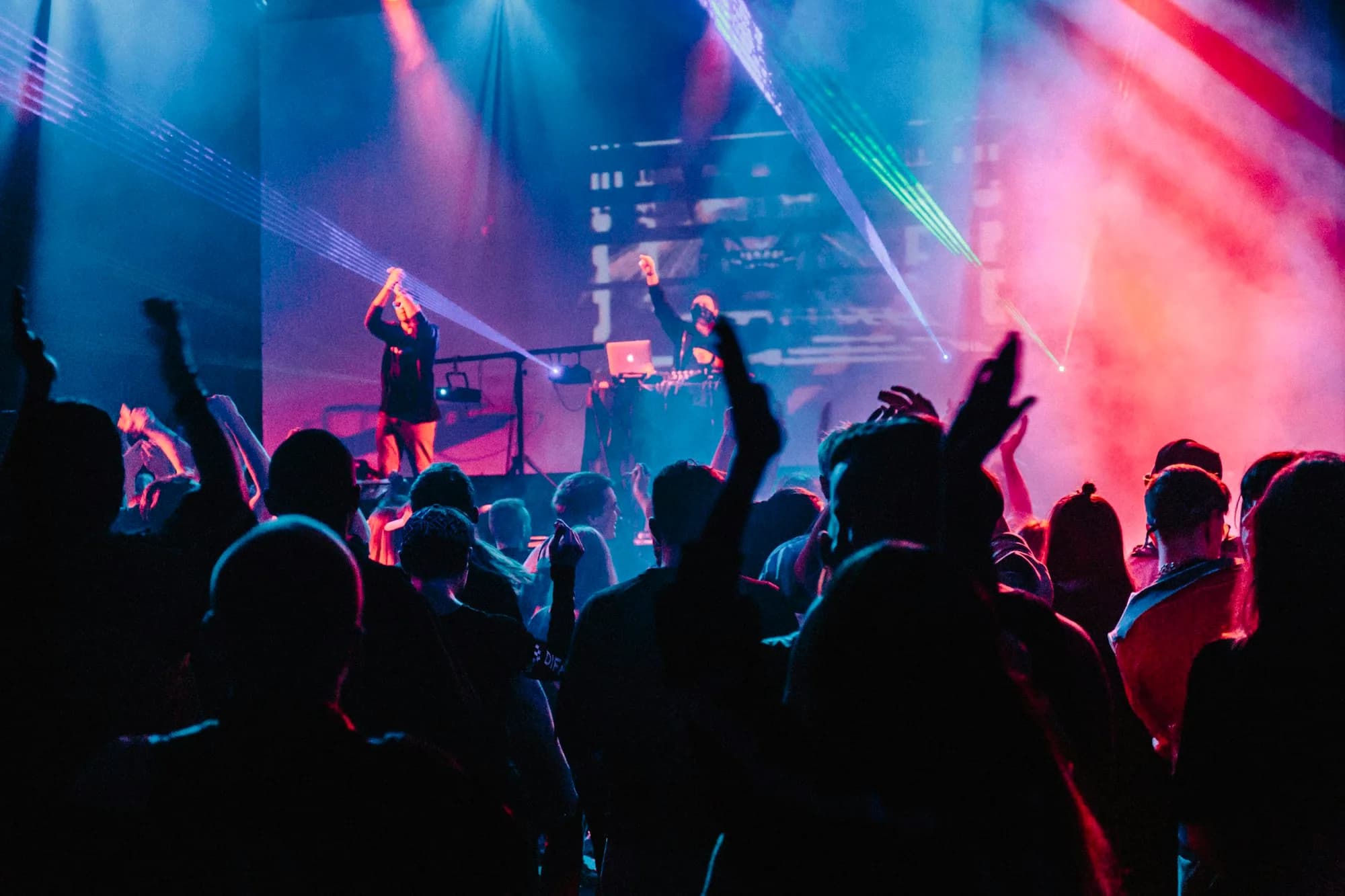 A DJ booth with controllers in low light